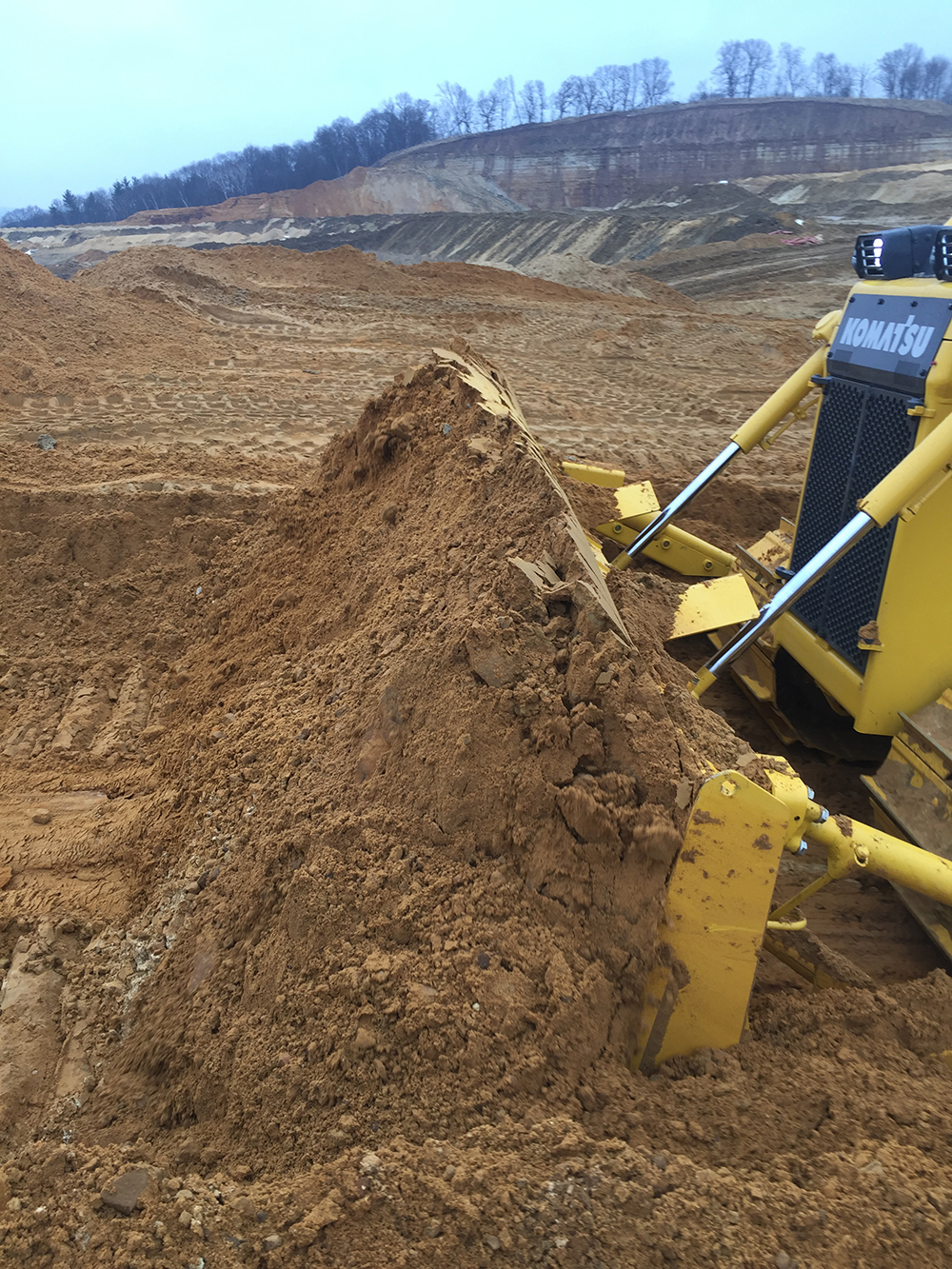 Excavator loading a haul truck from the face of a steep cut
