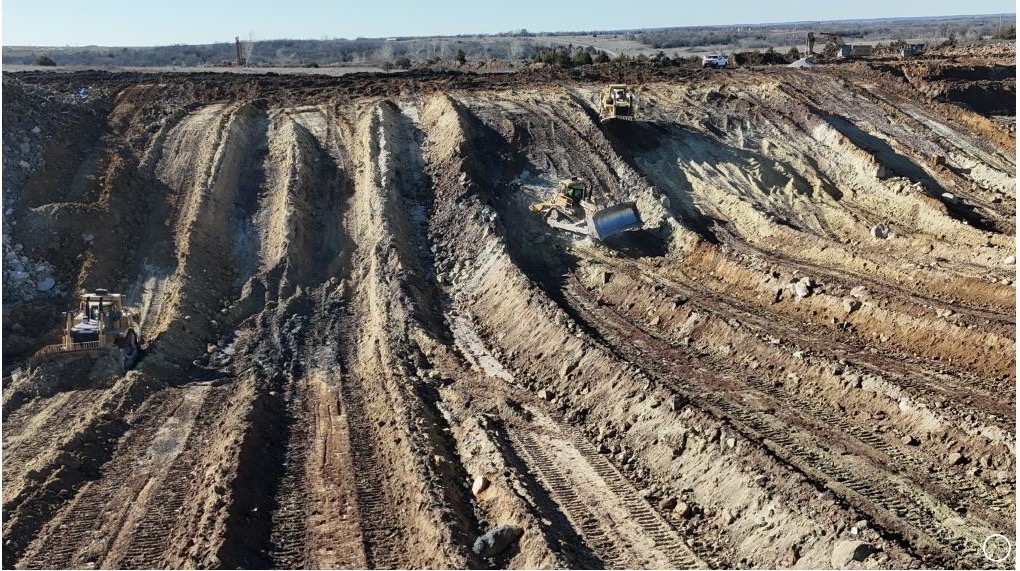 Multiple earthmoving machines working across a broad active excavation