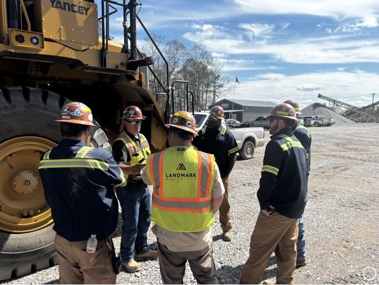 A Collup Enterprises training team coaching operators beside a large haul truck