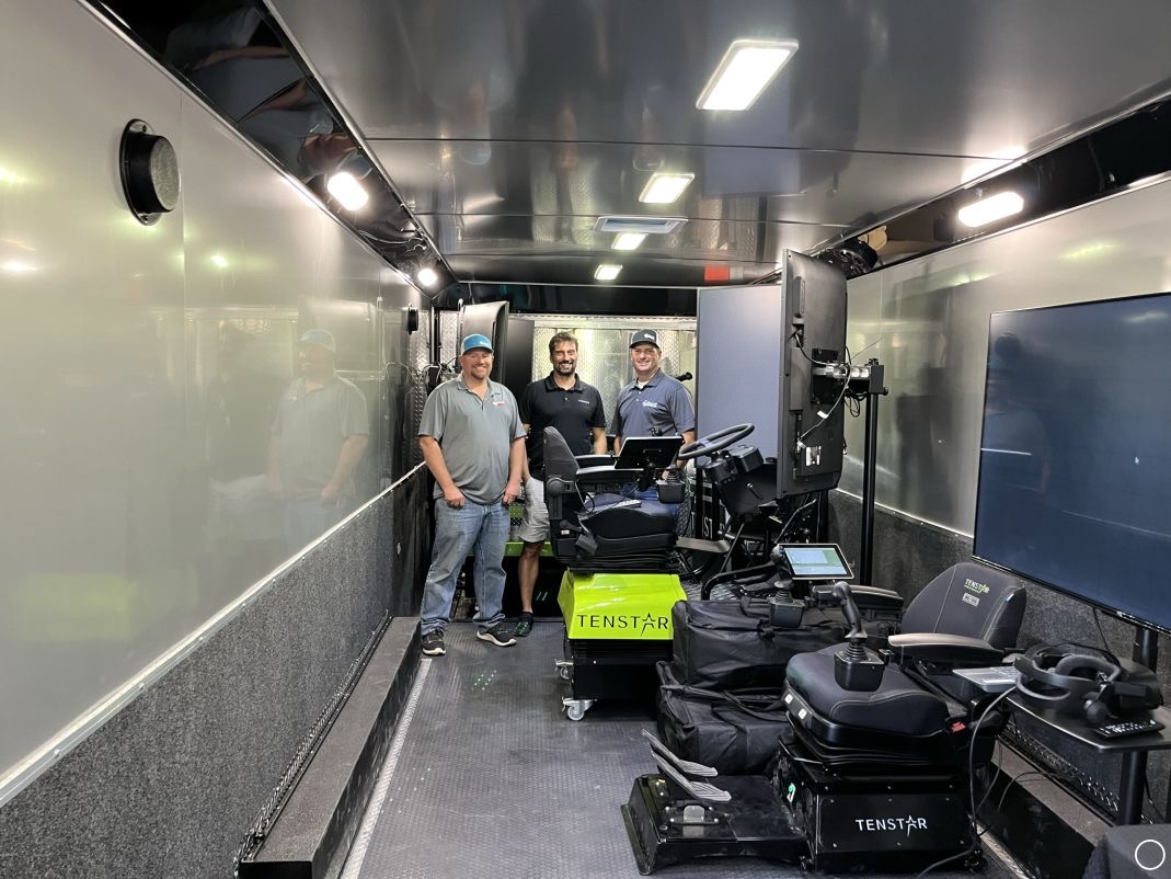 Three crew members inside the Collup Enterprises mobile simulator training trailer