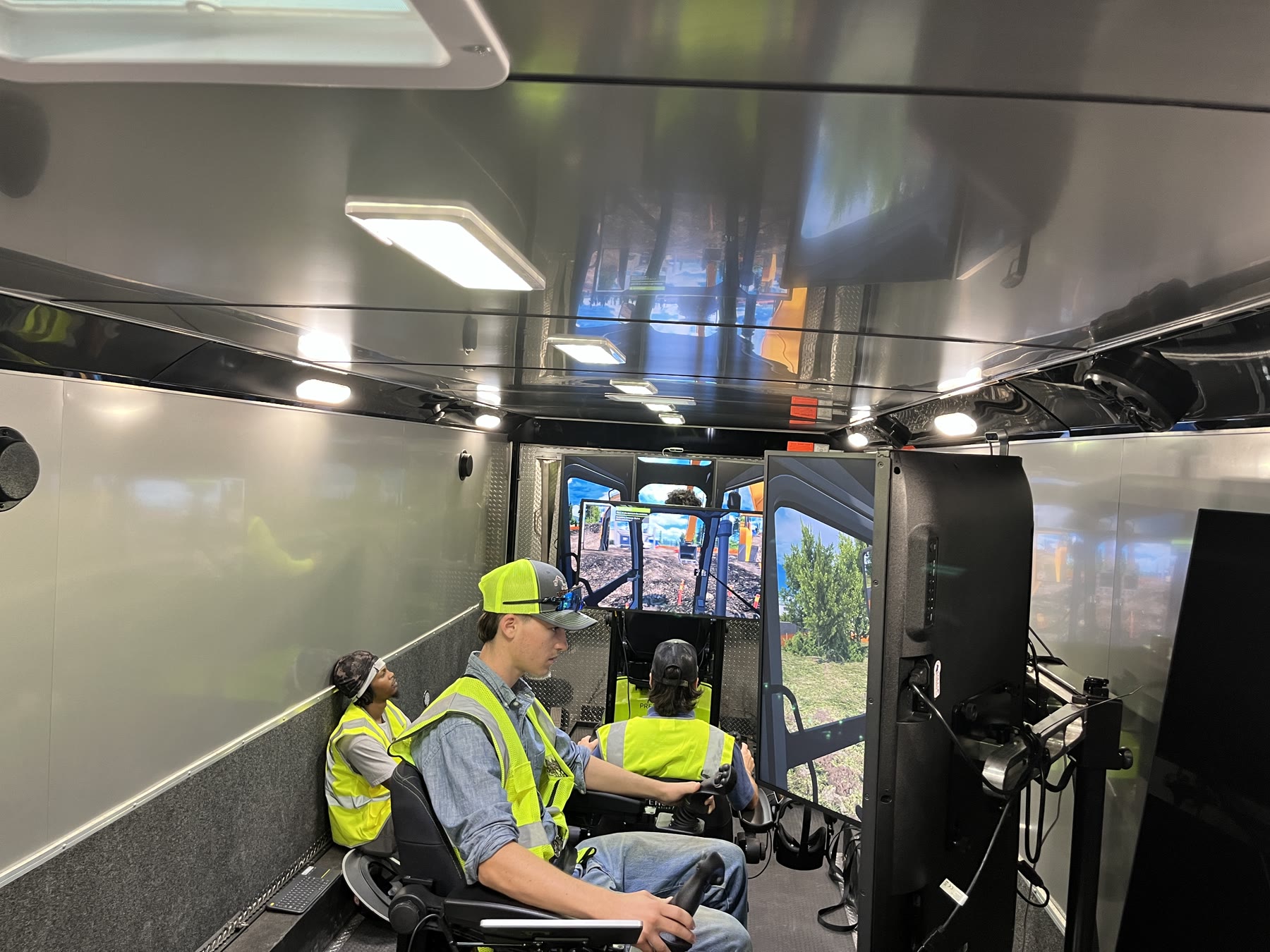 Three operators working at simulator stations during a guided mobile training session